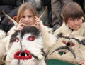 Girls Kukeri, kids mummers perform rituals with costumes and big bells on international festival of masquerade games Ã¢â¬ÂSurvaÃ¢â¬Â